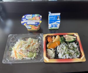 千切りキャベツ、もち麦入りご飯のお弁当、フルーツヨーグルト、牛乳